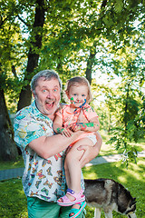 Image showing Two-year old girl stained in colors against green lawn