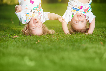 Image showing The two little baby girls hanging upside down