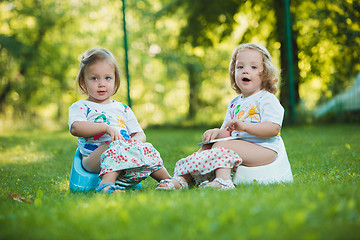 Image showing The two little baby girls hanging upside down