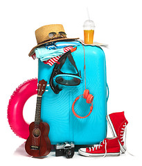 Image showing The blue suitcase, sneakers, hat and rubber ring on white background.