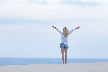 Image showing Free woman enjoying freedom on beach at dusk.