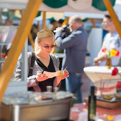 Image showing Woman buying meal at street food festival.