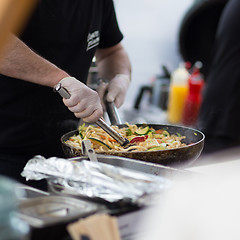 Image showing Cheff cooking on outdoor street food festival.