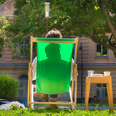 Image showing Silhouette of relaxed man on deckchair in a park