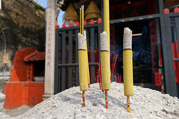 Image showing Three burning incense in front of Chinese temple