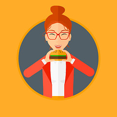 Image showing Woman eating hamburger.