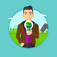 Image showing Man holding light bulb with tree inside.