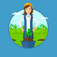 Image showing Woman pushing wheelbarrow with plant.