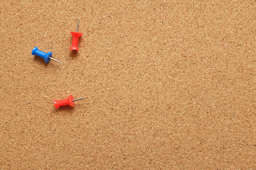 Image showing Three push pins on a cork noticeboard