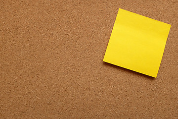 Image showing Yellow sticky note stuck on cork board