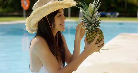 Image showing Young woman sipping a pineapple cocktail