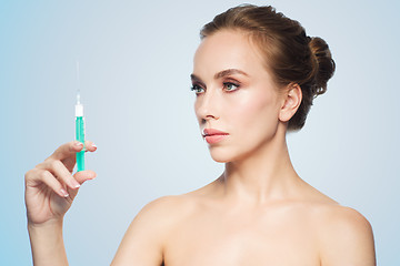Image showing beautiful woman holding syringe with injection