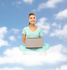 Image showing happy young woman with laptop sitting on cloud