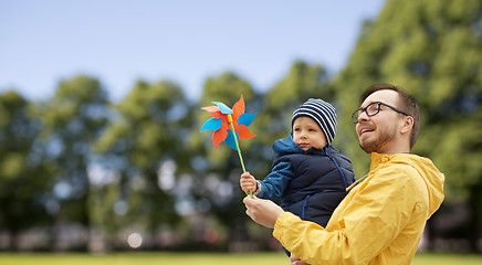 Image showing happy father and son with pinwheel toy outdoors