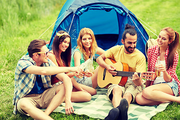 Image showing happy friends with drinks and guitar at camping