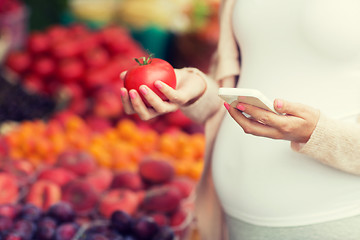 Image showing pregnant woman with smartphone at street market