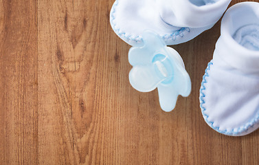 Image showing close up of baby bootees and soother for newborn