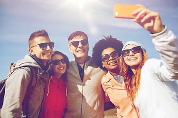 Image showing smiling friends taking selfie with smartphone