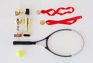 Image showing close up of tennis racket, ball, cups and medals