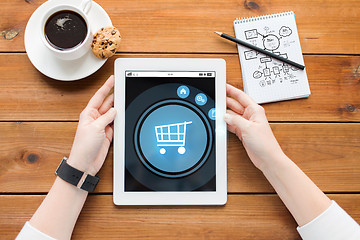 Image showing close up of woman with tablet pc on wooden table