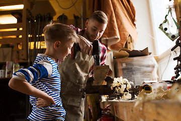 Image showing father and son with drill working at workshop