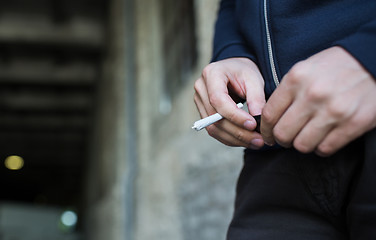 Image showing close up of addict hands with marijuana joint