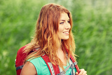 Image showing smiling young woman with backpack hiking in woods