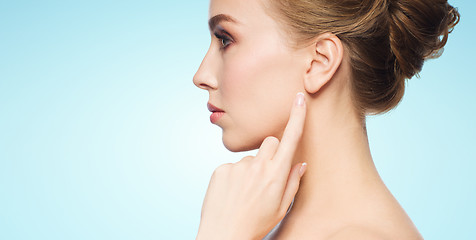 Image showing beautiful woman pointing finger to her ear