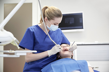 Image showing female dentist checking patient girl teeth