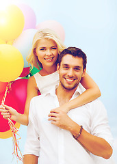 Image showing couple with colorful balloons at seaside