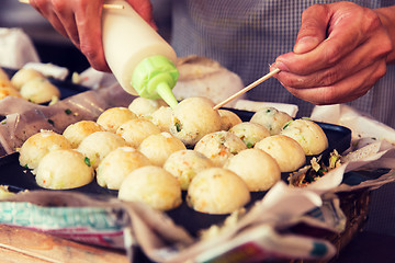 Image showing cook stuffing dough or rice balls at street market