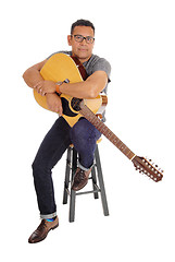 Image showing Hispanic man holding his guitar.