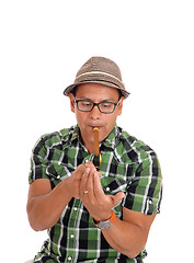 Image showing Hispanic man lightning his cigar.