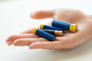 Image showing close up of hands holding alkaline batteries heap