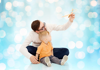 Image showing father and little son playing with toy airplane