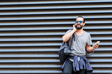 Image showing man with earphones and smartphone on city street