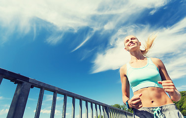 Image showing smiling young woman running outdoors