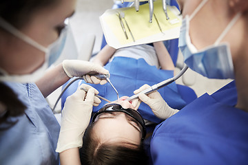 Image showing female dentists treating patient girl teeth