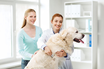 Image showing happy woman with dog and doctor at vet clinic