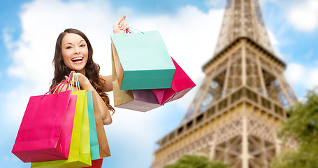 Image showing happy woman with shopping bags over eiffel tower