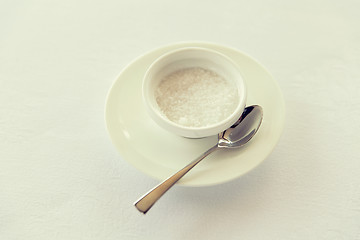 Image showing sugar bowl and saucer with spoon on table