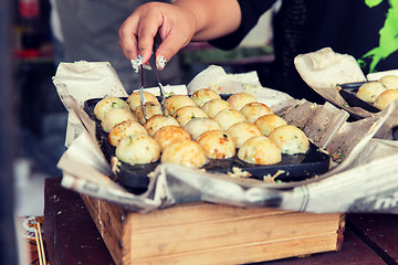 Image showing close up of cook hands with meatballs at street