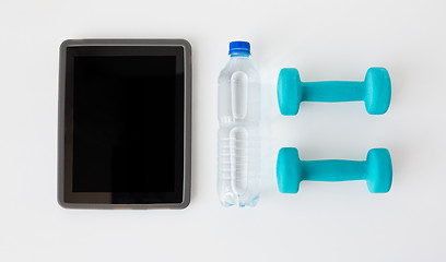 Image showing close up of tablet pc, dumbbells and water bottle