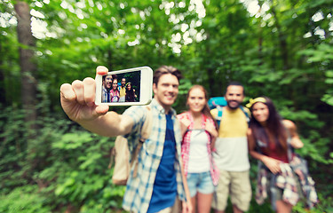 Image showing friends with backpacks taking selfie by smartphone