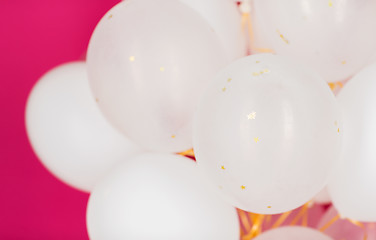 Image showing close up of white helium balloons over pink