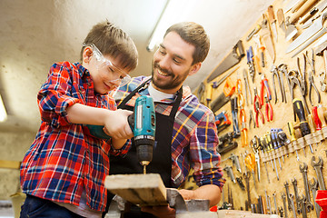 Image showing father and son with drill working at workshop