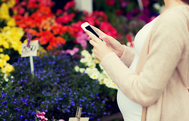 Image showing pregnant woman with smartphone at flower market