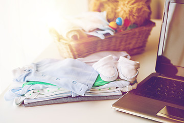 Image showing close up of baby clothes, toys and laptop