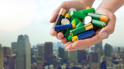 Image showing close up of hands holding alkaline batteries heap