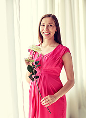 Image showing happy pregnant woman with rose flower at home